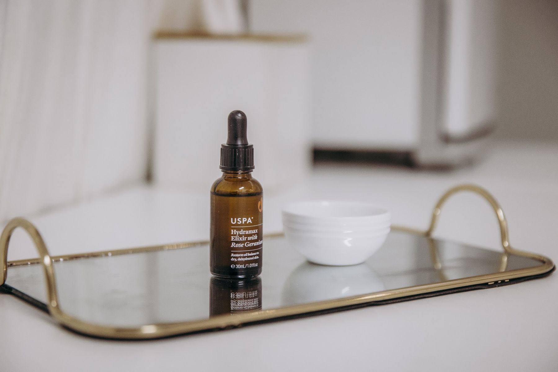 Serum bottle on gold tray | Glow Skin & Spa, Baldivis